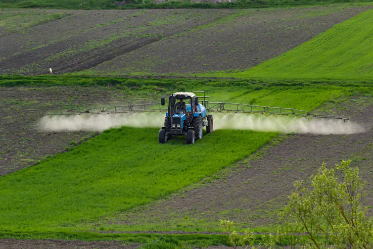 Aerial view of a tractor spraying a field.