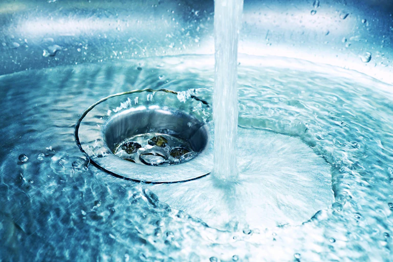 Water pouring into plughole