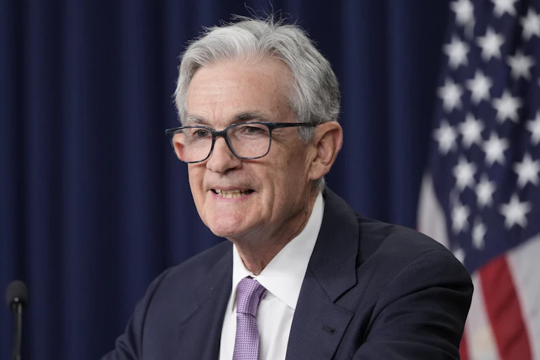 Fed chair Jay Powell smiles in front of American flag