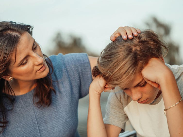 Mother comforts her son.