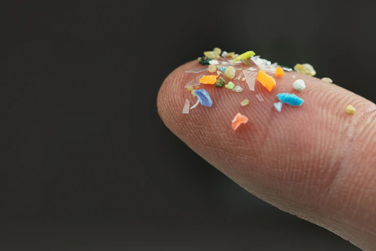 fingertips holding small plastic fragments