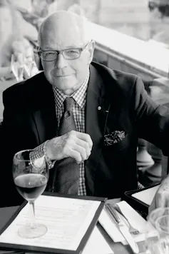 A man in glasses, suit and tie at a restaurant table