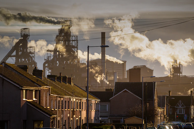 Residential street with industrial plant in the background.