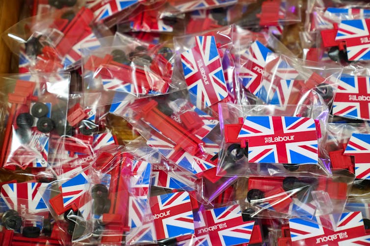 A pile of Labour union flag badges in plastic wrapping.