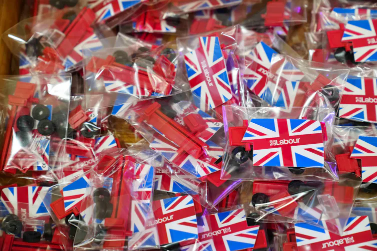 A pile of Labour union flag badges in plastic wrapping.