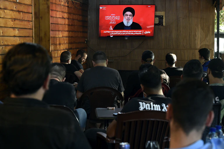 Hezbollah chief Hasssan Nasrallah addresses the Lebanese people via a TV broaqdcast as people watch in a cafe, September 19 2024.