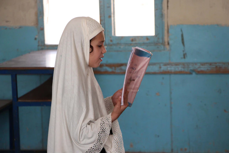 A girl reading in a classroom