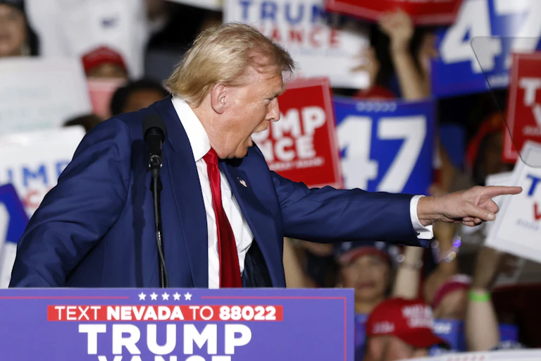 Donald Trump pointing and shouting passionately at a campaign rally.