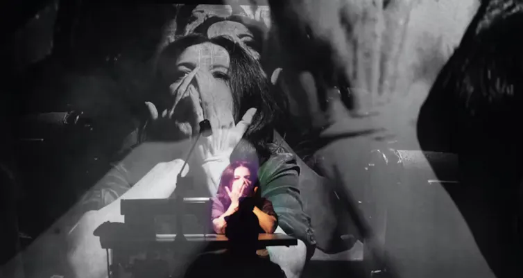Woman on stage covering her face