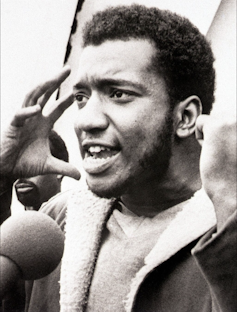 A young black man addressing a rally in the 1960s.