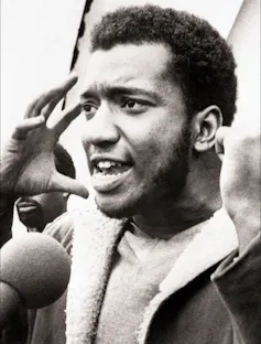 A young black man addressing a rally in the 1960s.