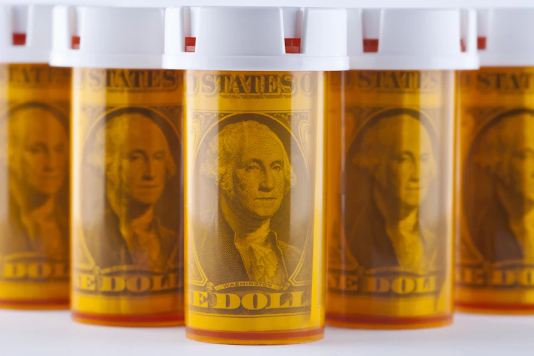 Array of orange pill bottles with dollar bills inside, George Washington facing the viewer