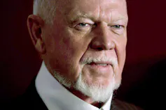 A close up shot of an older man with a trimmed white beard