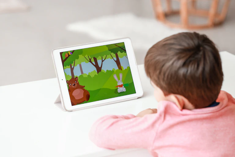 A child seen from behind watching a cartoon on a tablet