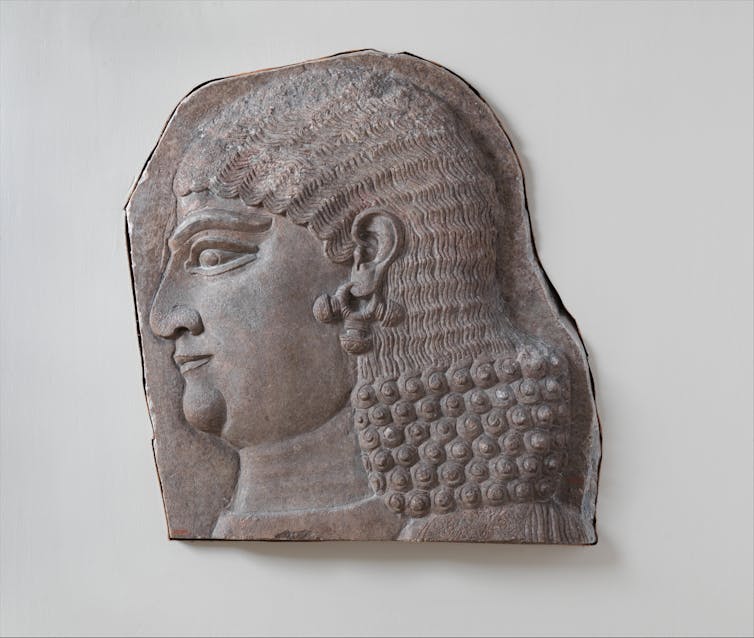 This Assyrian  relief shows the head of a beardless royal attendant, possibly a eunuch. Eunuchs were key figures in the Assyrian court and palace.