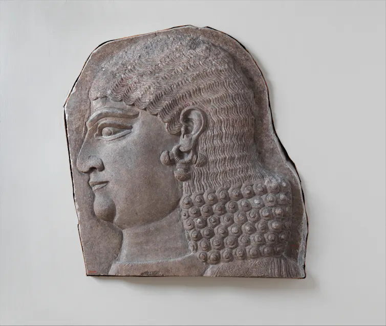 This Assyrian relief shows the head of a beardless royal attendant, possibly a eunuch. Eunuchs were key figures in the Assyrian court and palace.