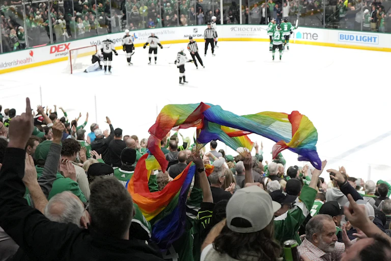 Fans wave a rainbow flag during an NHL game.
