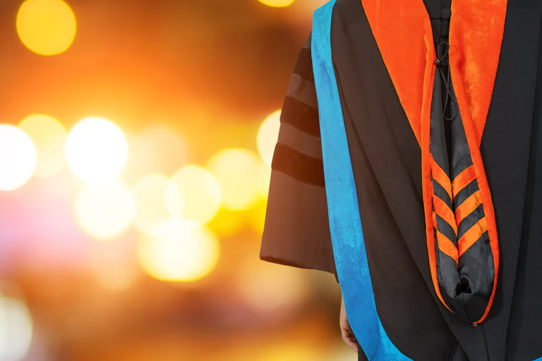 PhD graduate in black gown university bachelor degree