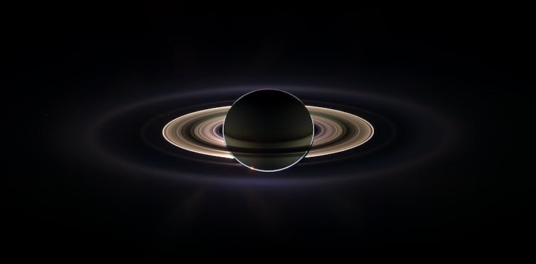 Saturn with its rings glowing spectacularly against a black background.
