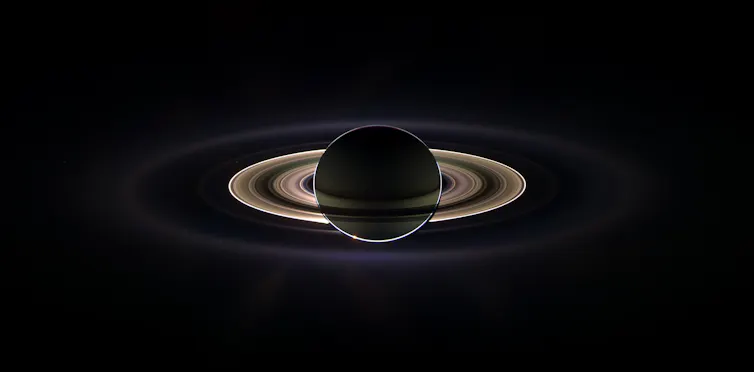 Saturn with its rings glowing spectacularly against a black background.