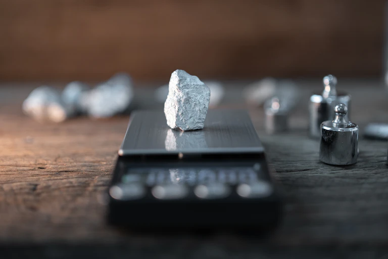 A chunk of silvery pale metal on a precision scale.