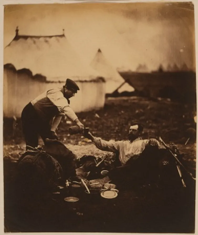 A man reclining while being waited upon.