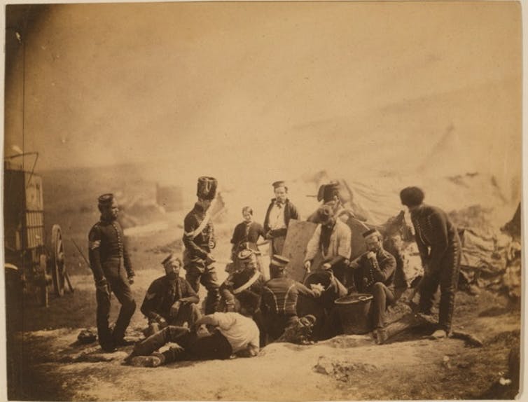 A group of people posing around a cooking area.
