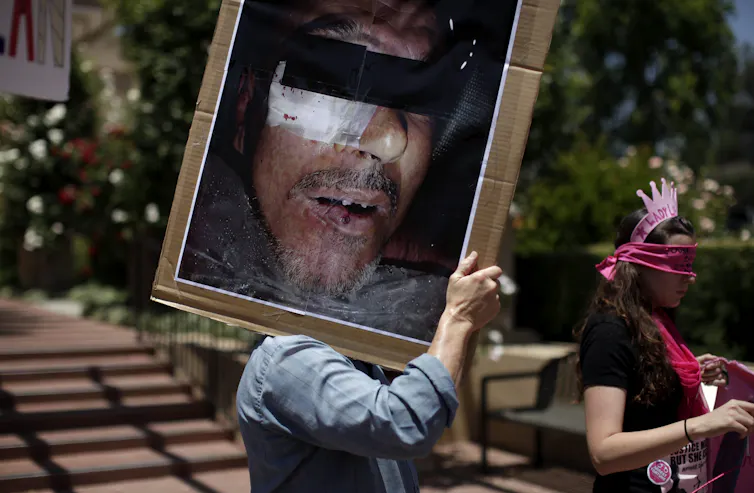 A protester with a placard with photograph of a man's face.