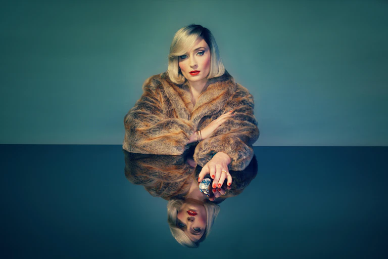 Sophie Turner with a blonde bob in a fur coat