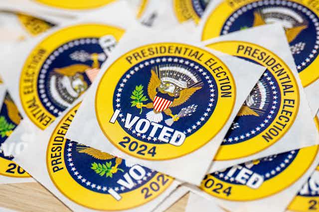Bright yellow and blue stickers with the presidential seal on them that say 'PRESIDENTIAL ELECTION 2024' and 'I VOTED.'