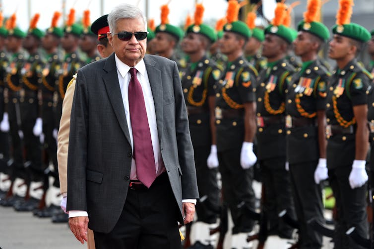 Ranil Wickremesinghe walking past a line of Sri Lankan soldiers.