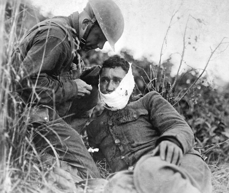 A wounded American soldier, receiving first-aid treatment in the first world war.