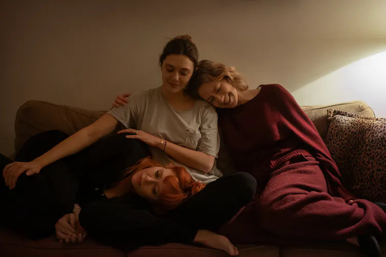 The three sisters sitting together on a sofa.