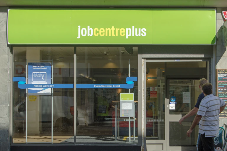 men walk past a branch of jobcentre plus
