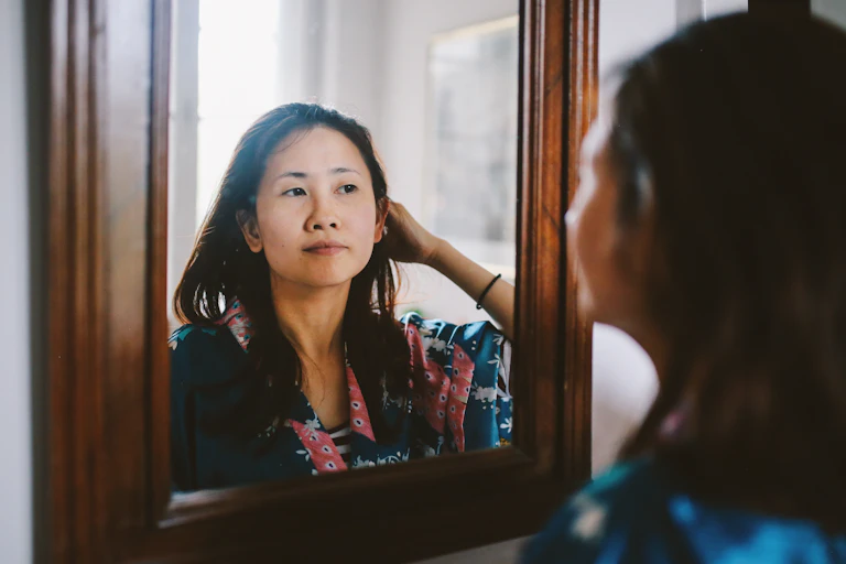 woman looking at herself in the mirror