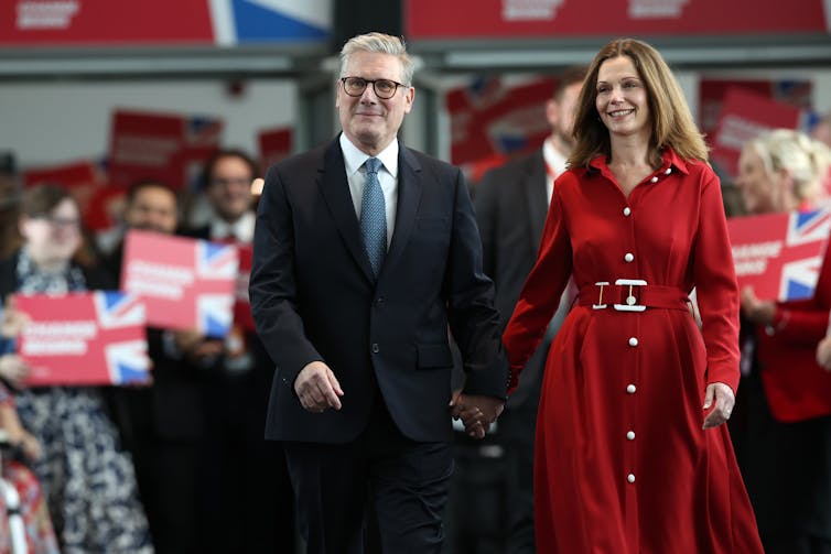 Keir and Victoria Starmer walking in front of a crowd.