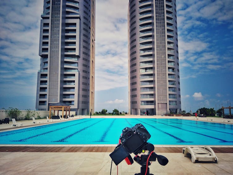 Two skyscrapers towering above a swimming pool.