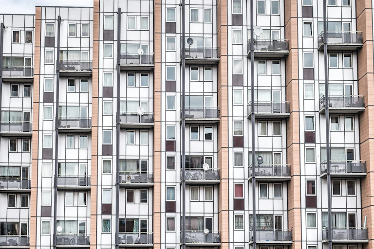 Facade of apartment building with large antenna on the roof.