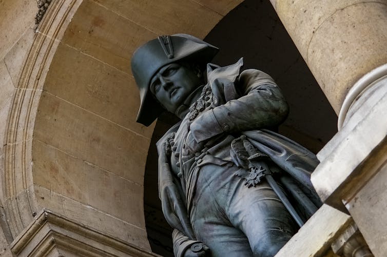 A statue of Napoleon Bonaparte in a sandstone arch