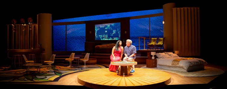 Production image: a man and a woman work on a puzzle.