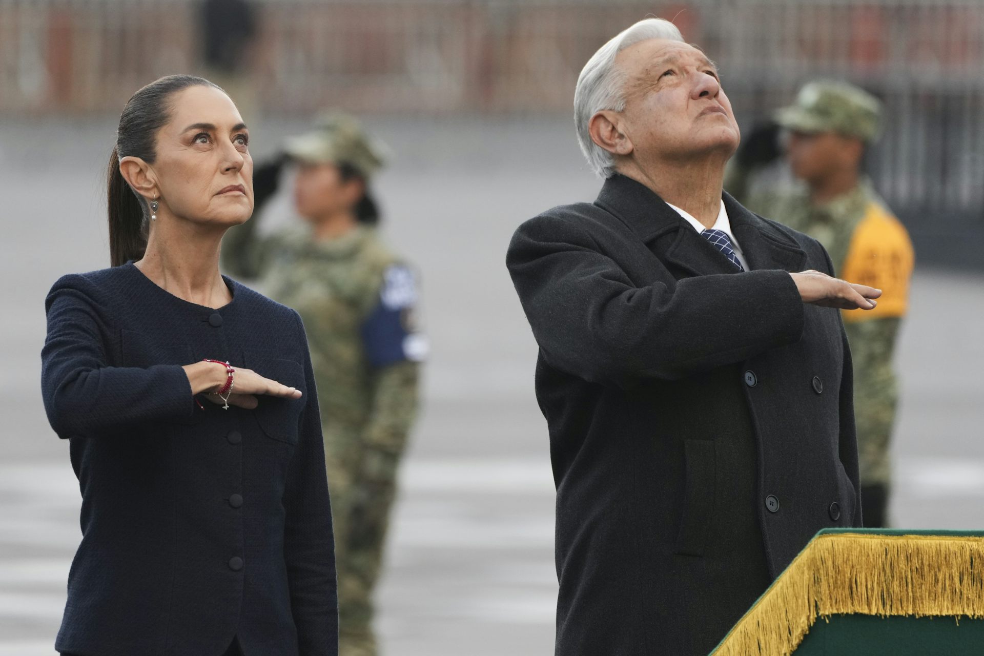 Lopez Obrador and Sheinbaum standing together at a memorial event.