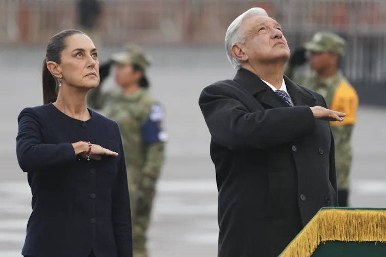 Lopez Obrador and Sheinbaum standing together at a memorial event.
