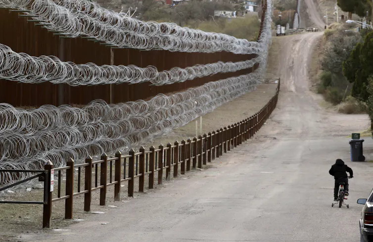 A barbed-wire border wall.