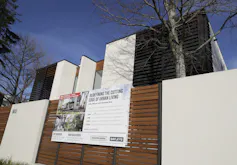 A house with an auction board on the fence