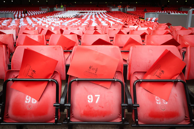 Red stadium seats holding red and white flyers
