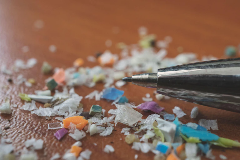 Microplastics next to the nib of a pen for comparison