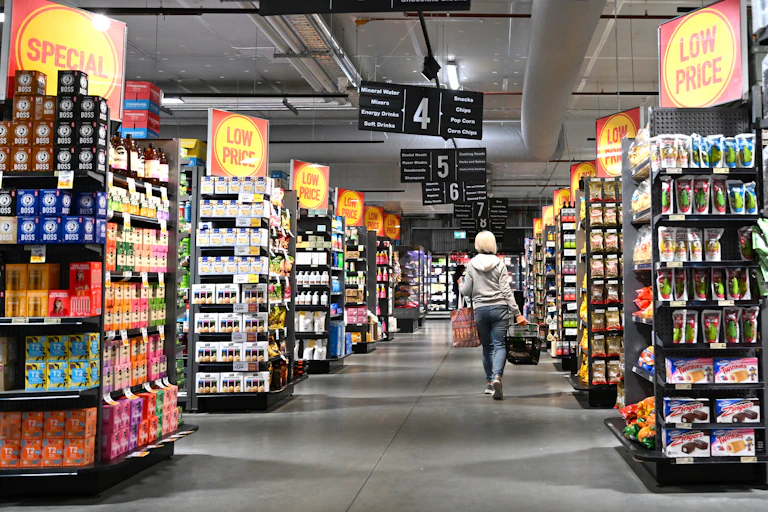 A woman walks through a supermarket.