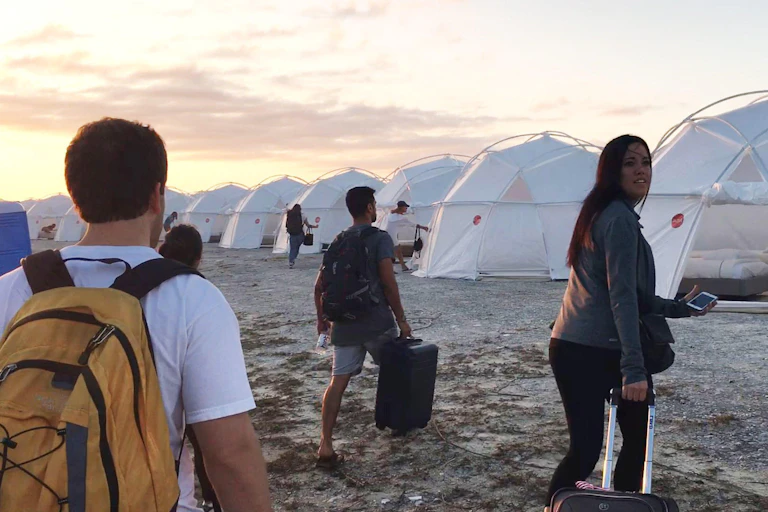 Fyre festival attendees walk towards emergency shelter tents