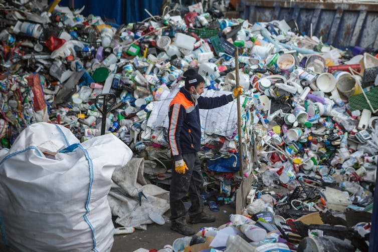 A trash collector working among at a waste collection facility.