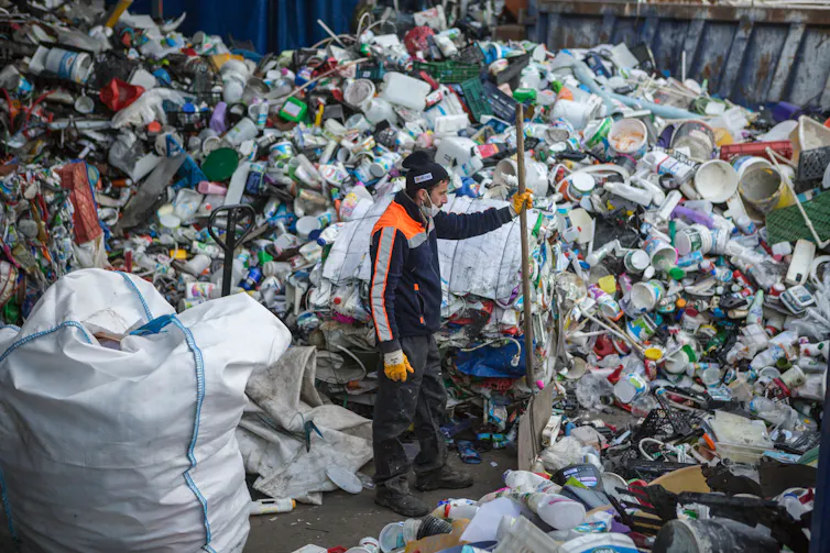A trash collector working among at a waste collection facility.
